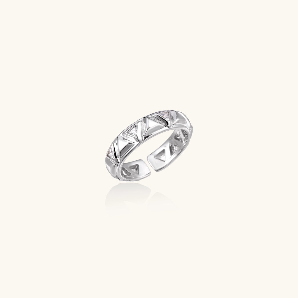 White gold adjustable ring with geometric triangle cutouts and zirconia stones on cream background