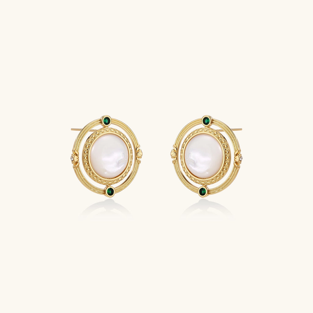 Circular gold stud earrings with iridescent mother-of-pearl center and green zirconia accents on cream background.