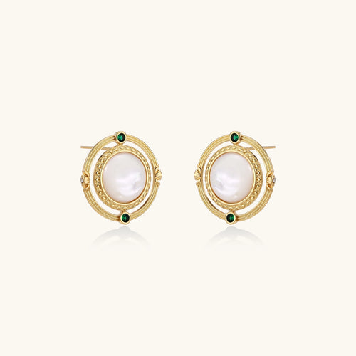 Circular gold stud earrings with iridescent mother-of-pearl center and green zirconia accents on cream background.