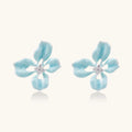 Turquoise enamel flower stud earrings with marbled finish and crystal centers on 18K gold plated brass