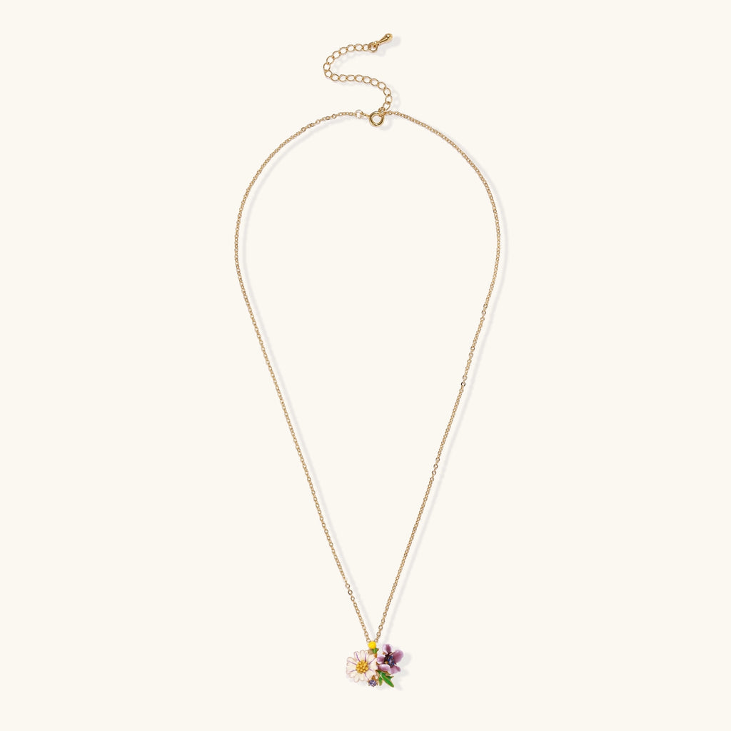 Gold-plated necklace with pink and purple enamel flower pendant featuring crystal accents on cream background