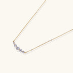 Delicate 14K gold-plated necklace with five graduated zirconia stones arranged in a curved arc on fine chain