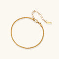 Delicate 18K gold-plated stainless steel bracelet with textured beaded chain on cream background