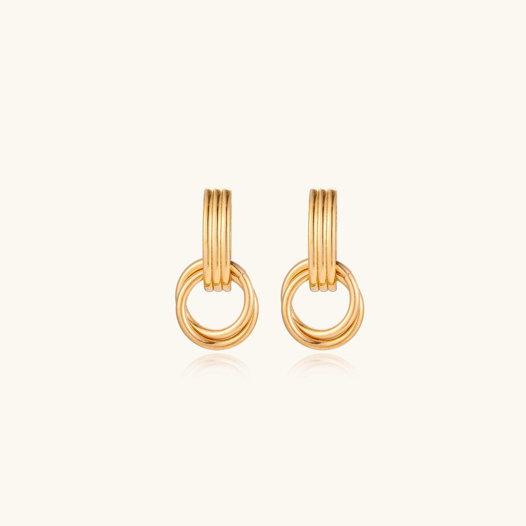 Gold stud earrings with vertical ridged bar connecting to triple interlocking circular rings on white background