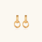 Gold stud earrings with vertical ridged bar connecting to triple interlocking circular rings on white background