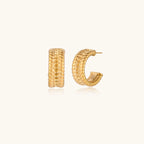 Textured gold huggie hoop earrings with raised ribbed rows creating dimensional sculptural design on cream background