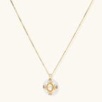 Gold-plated necklace with circular white enamel pendant featuring central zirconia stone and ornate decorative details