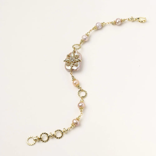 Gold-plated bracelet with pink baroque pearl centerpiece, floral connector, and freshwater pearls
