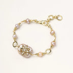 Gold-plated bracelet with pink baroque pearl centerpiece, floral connector, and freshwater pearls