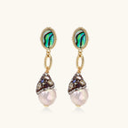 Gold drop earrings with iridescent abalone studs, rope links, jeweled caps and white baroque pearls on cream background