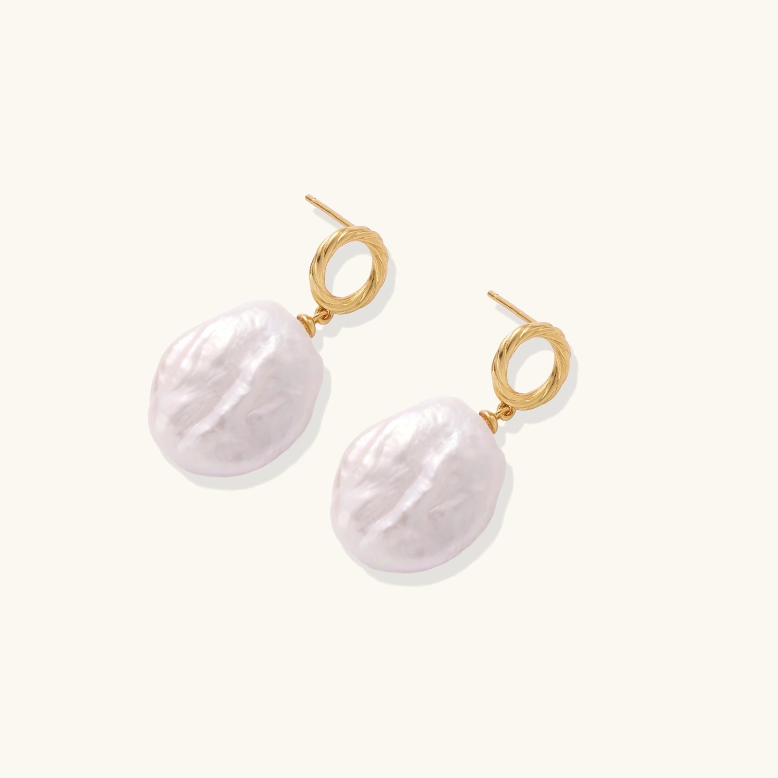 18K gold vermeil twisted circle studs with organic white baroque pearl drops on cream background
