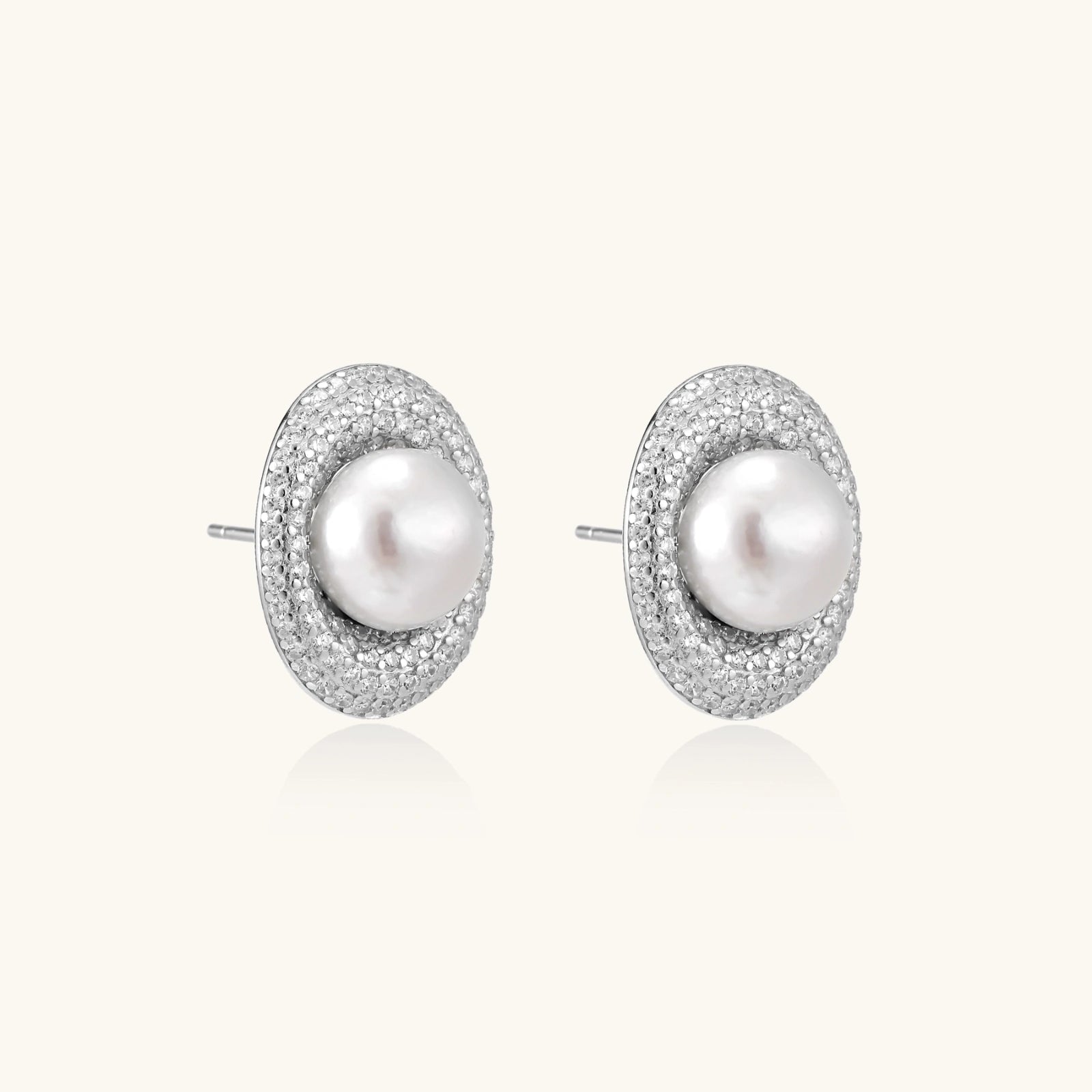 Elegant stud earrings with cream freshwater pearls surrounded by sparkly pavé crystals on rhodium-plated silver setting