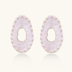 Oval lavender enamel earrings with marbled finish and gold-plated beaded border on cream background.