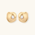 Organic-shaped eco-zinc alloy stud earrings with resin pearl centers and sterling silver posts on white background.