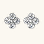 Dainty sterling silver quatrefoil stud earrings with four brilliant moissanite stones and center accent on white background.