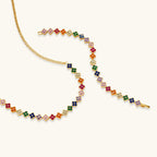 Colorful four-leaf clover jewelry set with rainbow cubic zirconia stones in gold-plated setting on white background