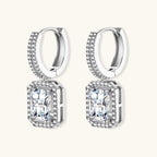 Sterling silver huggie hoops with emerald-cut moissanite drops featuring pavé-set crystals on white background.