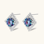 Diamond-shaped sterling silver stud earrings with rainbow moissanite centers surrounded by crystal halos