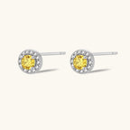 Dainty sterling silver stud earrings with yellow moissanite center stones surrounded by white halo stones